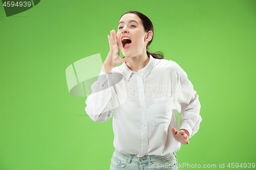 Image of Isolated on green young casual woman shouting at studio