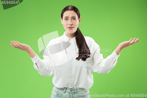 Image of The happy business woman standing and smiling against green background.