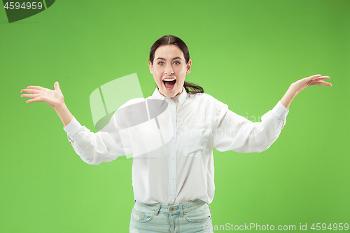 Image of Beautiful woman looking suprised isolated on green