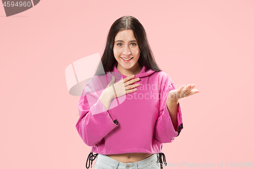 Image of The happy business woman standing and smiling against pink background.