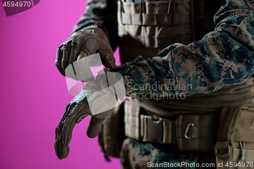 Image of closeup of soldier hands putting protective battle gloves pink b