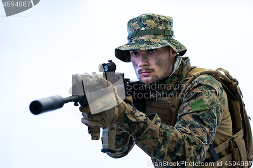 Image of soldier in action aiming laseer sight optics