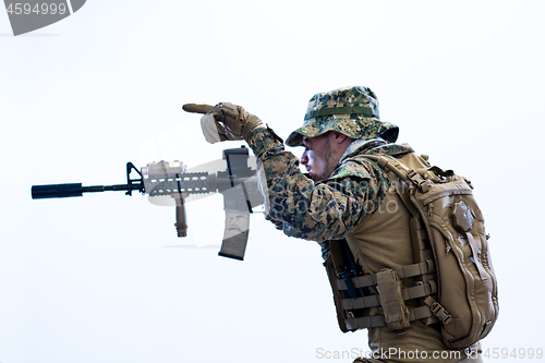 Image of soldier in action aiming laseer sight optics