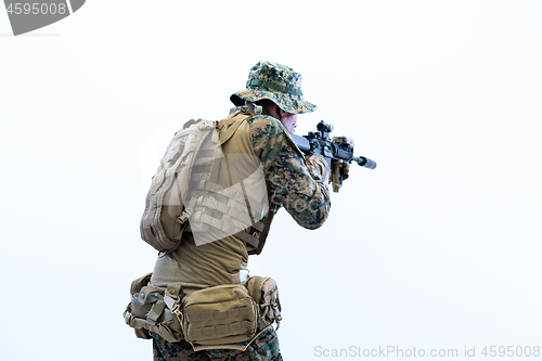 Image of soldier in action aiming laseer sight optics