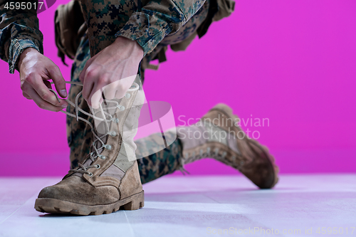 Image of soldier tying the laces on his boots