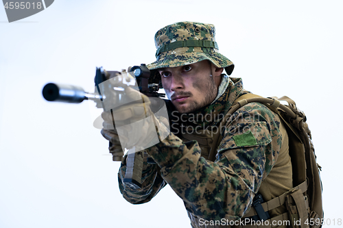 Image of soldier in action aiming laseer sight optics