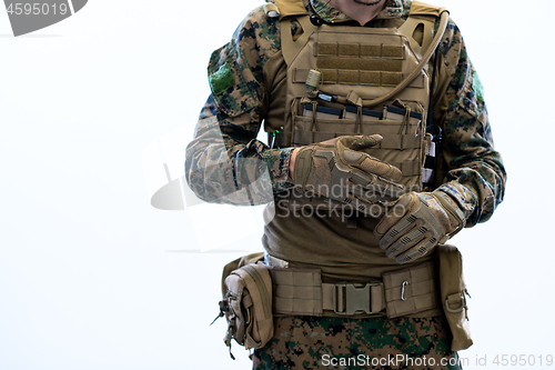Image of closeup of soldier hands putting protective battle gloves