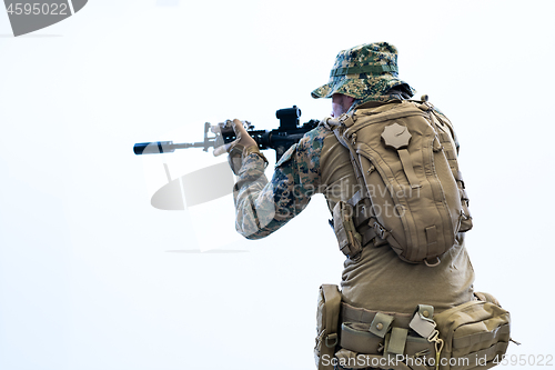 Image of soldier in action aiming laseer sight optics