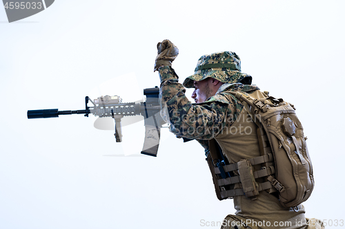 Image of soldier in action aiming laseer sight optics