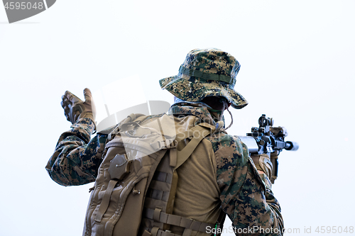 Image of soldier in action giving comands to team by hand sign