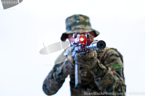 Image of soldier in action aiming laseer sight optics