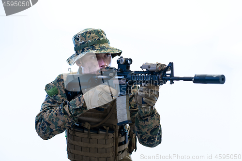 Image of soldier in action aiming laseer sight optics