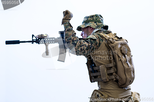 Image of soldier in action aiming laseer sight optics