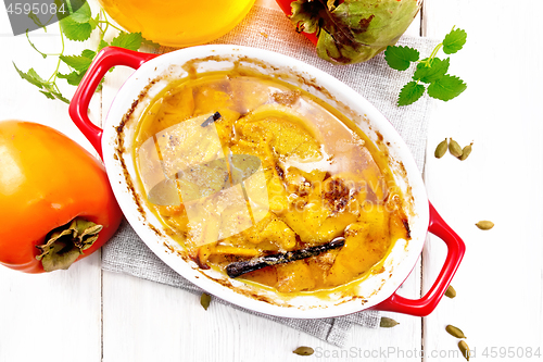 Image of Persimmons baked with honey in pan on light board top