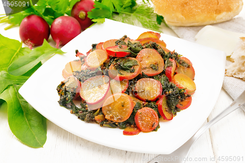 Image of Radish with spinach and spices in plate on white wooden board