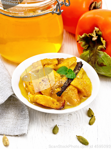 Image of Persimmons baked with honey in dish on white board