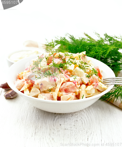 Image of Salad of surimi and eggs with mayonnaise on wooden table