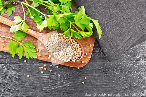 Image of Coriander seeds in spoon on black board top