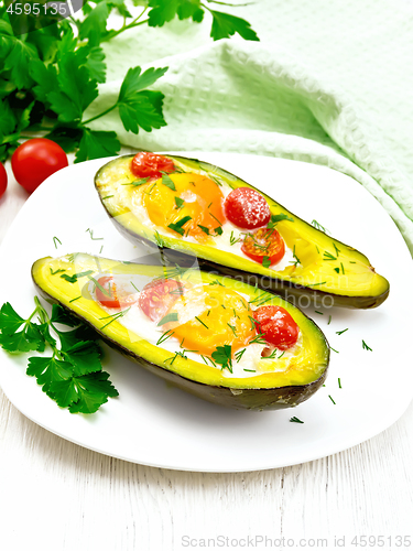 Image of Scrambled eggs with tomatoes in avocado on light table