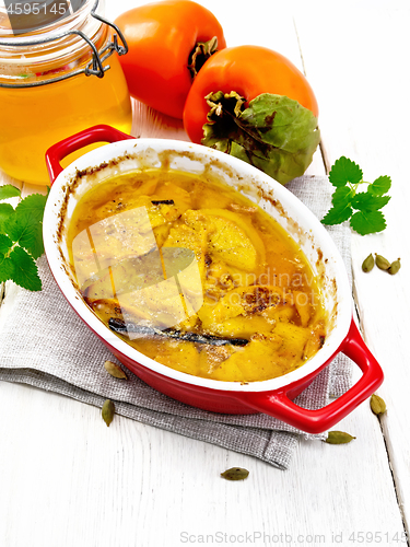 Image of Persimmons baked with honey in pan on white board