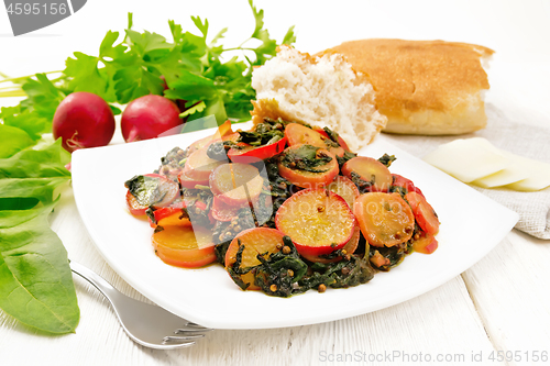 Image of Radish with spinach and spices in plate on light wooden board