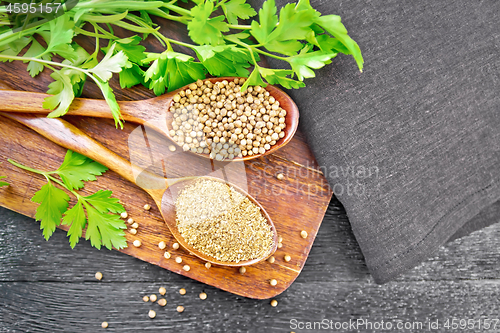 Image of Coriander ground and seeds in two spoons on black board top