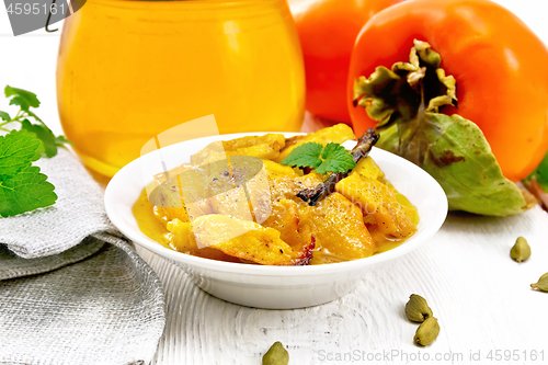 Image of Persimmons baked with honey in dish on light board