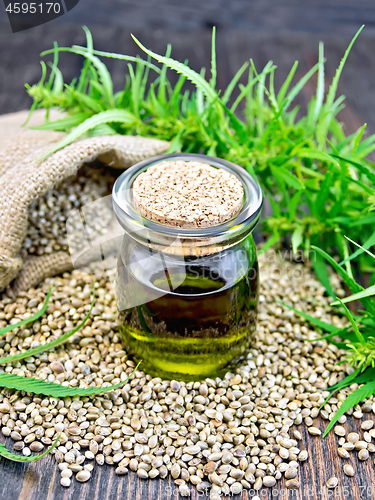 Image of Oil hemp in jar with seed on dark board