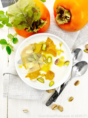 Image of Dessert of yogurt and persimmon in bowl on board top