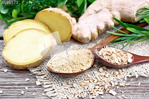 Image of Ginger ground and flakes in spoons with root on old board