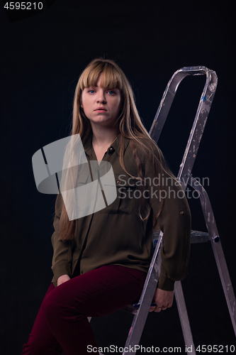 Image of Psychological portrait of a girl sitting on a ladder