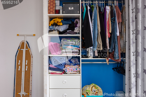 Image of Fragment of the interior of the room, a closet with linen, next to an ironing board