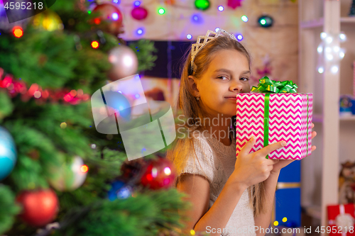 Image of Happy girl with a gift at the Christmas tree