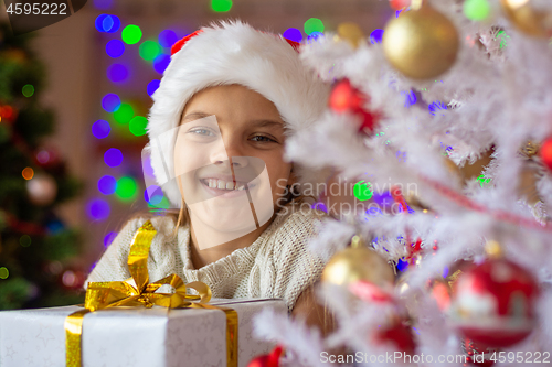 Image of Portrait of a close-up of a beautiful girl with a New Year\'s gift