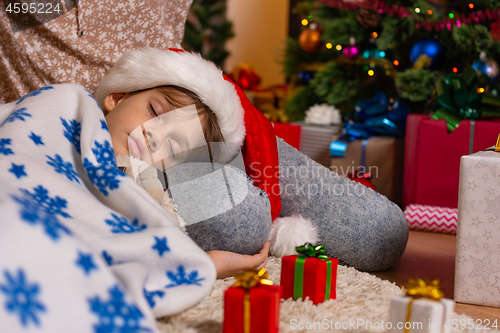 Image of Girl lies on mom\'s lap at Christmas tree