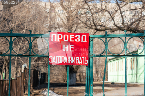 Image of The inscription \"do not block the passage\" in Russian on the street gate