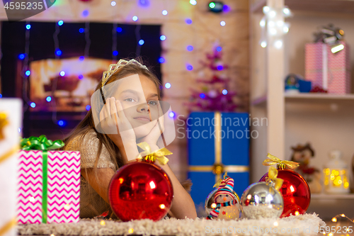 Image of Girl dreams of a New Year\'s gift, lying on the mat in the New Year\'s interior