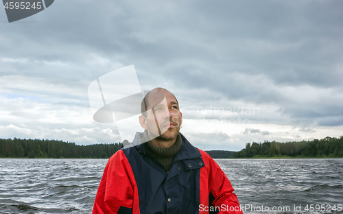 Image of Mature Man Against A Overcast Landscape With A Lake