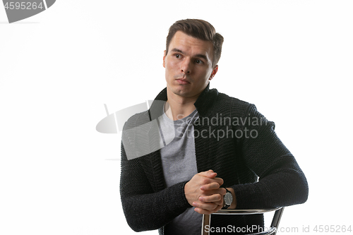 Image of The young guy thought hard, sitting on a chair