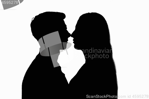 Image of Two people in a counterlight touched each other with their noses