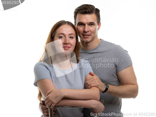 Image of Portrait of a happy and cheerful young couple, a guy hugs a girl