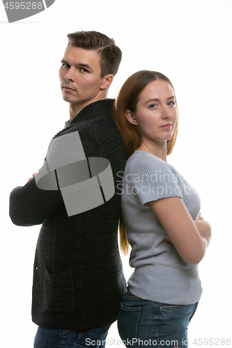 Image of A couple with big problems stand with their backs to each other and look into the frame