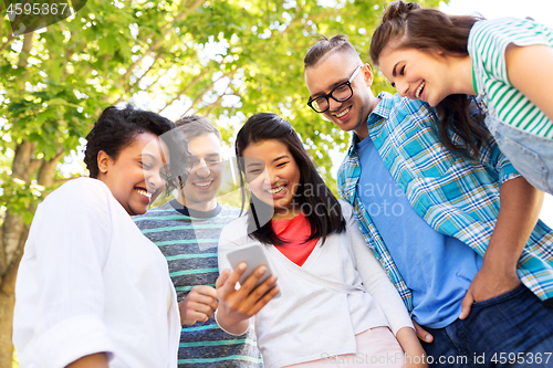 Image of happy friends with smartphone at summer park