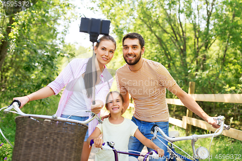 Image of happy family with bicycles taking selfie in summer