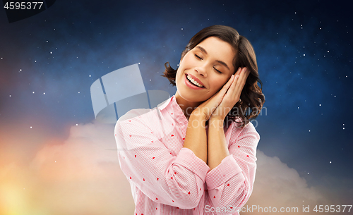 Image of happy woman in pajama making sleeping gesture