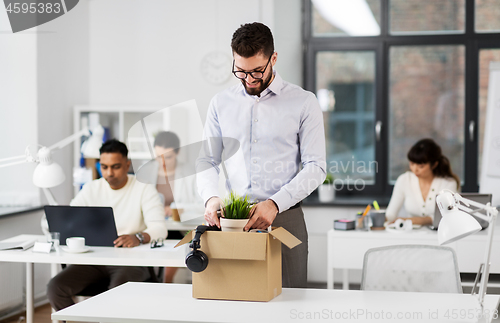 Image of happy male office worker with personal stuff