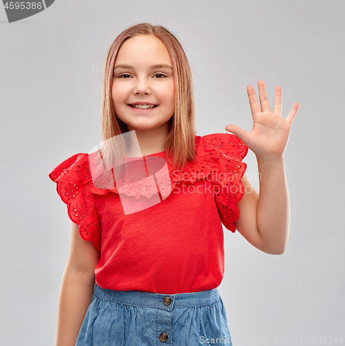 Image of smiling girl in red shirt showing five fingers