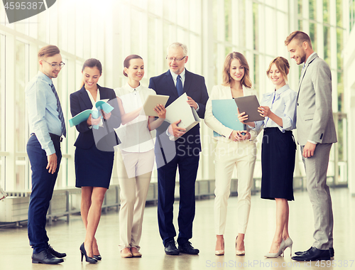 Image of business team with tablet pc and folders at office