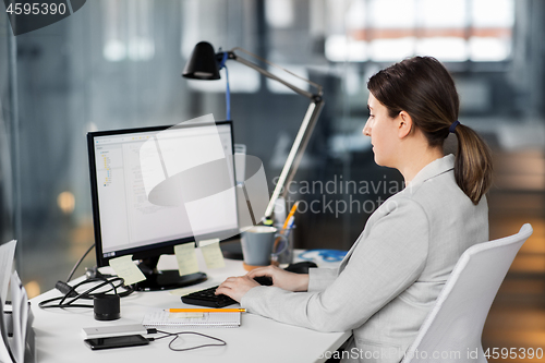 Image of businesswoman with computer working at office