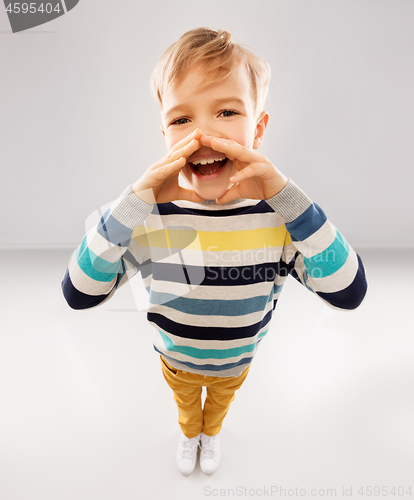 Image of little boy in striped pullover calling someone